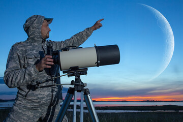 A European man is watching the moon through a telescope. Amateur astronomer.