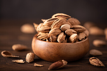 fresh inshell almonds in a wooden bowl