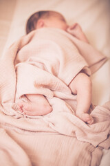 Portrait of a cute adorable white Caucasian baby newborn in diaper, sleeping dreaming, lying on bed, covered with blanket, view from top above. Cute little baby sleeping on bed at home.