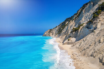 Fototapeta na wymiar The remote Egremni beach on Lefkada island, Greece, with its beautiful, turquoise sea and waves hitting the white rocks