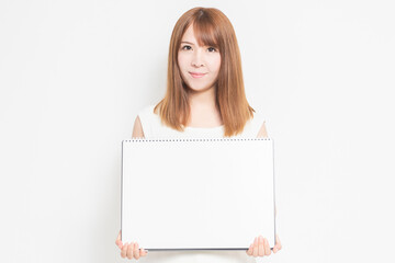 Fototapeta premium スケッチブックを持つ若い女性