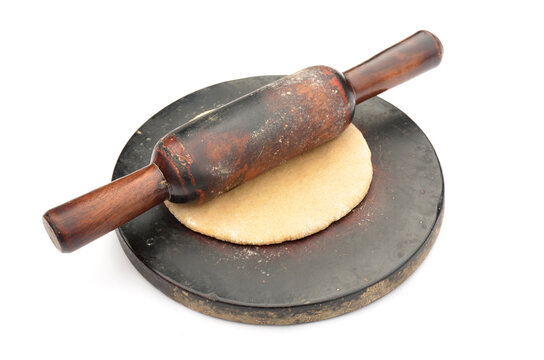 the brown wooden  chakla  bellan with unleavened bread.