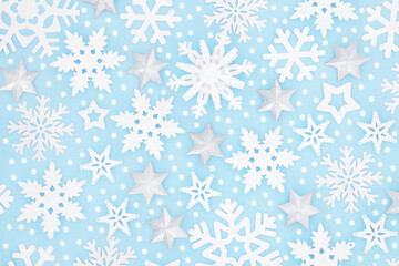 Christmas snowflake & silver star background pattern on pastel blue. Festive design for winter, Xmas & New Year holiday season. Top view, flat lay. 