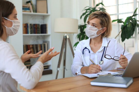 Middle Aged Female Doctor Therapist In Medical Mask On Consultation With Patient In Office.