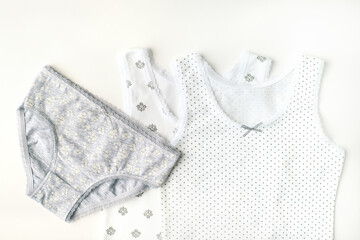 Children's underwear on a white background. Light soft linen for children. T-shirts and panties for girls. Baby clothes made of soft jersey.