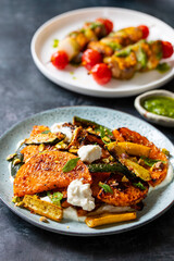 Roast butternut squash and courgettes with feta and yougurt sauce and salmon skewers