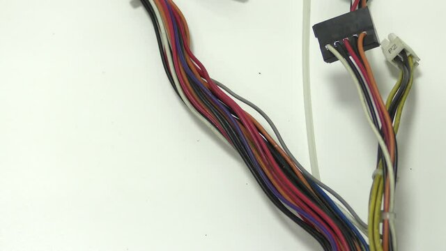 A worker frees a bundle of wires with pliers from a plastic tie.