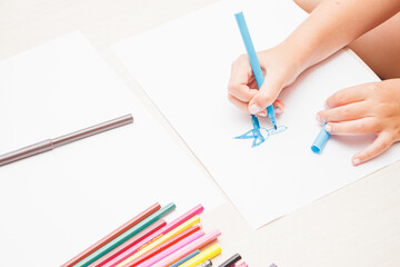 Favorite activity of the child. A happy family. The girl draws with colored markers. Girl's hands.