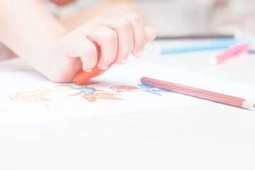 Favorite activity of the child. A happy family. The girl draws with colored markers. Girl's hands.