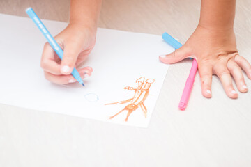 Favorite activity of the child. A happy family. The girl draws with colored markers. Girl's hands.