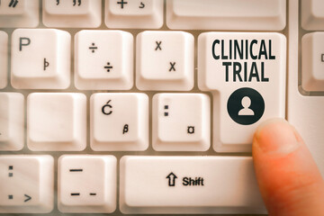 Word writing text Clinical Trial. Business photo showcasing evaluate the effectiveness and safety of medications Pc keyboard key with pointing finger above background copy space