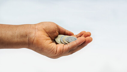 Money in hand for investment. Start small and grow your investment. A child holding some coin against a white background.