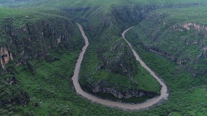 Aerial view of river in the mountain. Green hills.