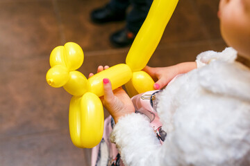 little girl playing with balloon made dog