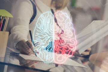 Multi exposure of woman's writing hand on background with brain hud. Concept of learning.