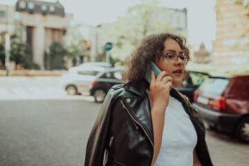 Obraz premium Happy african american young woman talking with cellphone in city