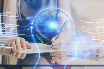Multi exposure of woman's writing hand on background with brain hud. Concept of learning.