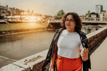 African woman glasses and modern clothes combination posing in modern city