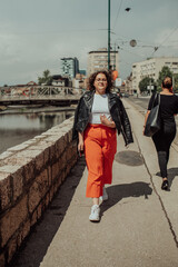 African woman glasses and modern clothes combination posing in modern city