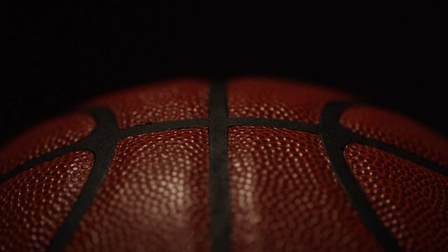 Static shot of symmetrical line pattern on a basketball under dramatic lighting