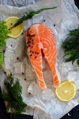 red fish steak on ice with herbs and spices