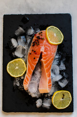red fish steak on ice with herbs and spices
