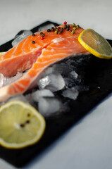red fish steak on ice with herbs and spices