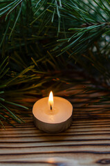 candle on the background of Christmas tree branches