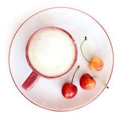 three sweet cherries on a plate next to a cup of cappuccino top view. coffee with summer mood