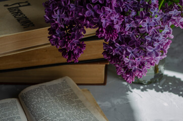 bouquet of lilacs on the table with books