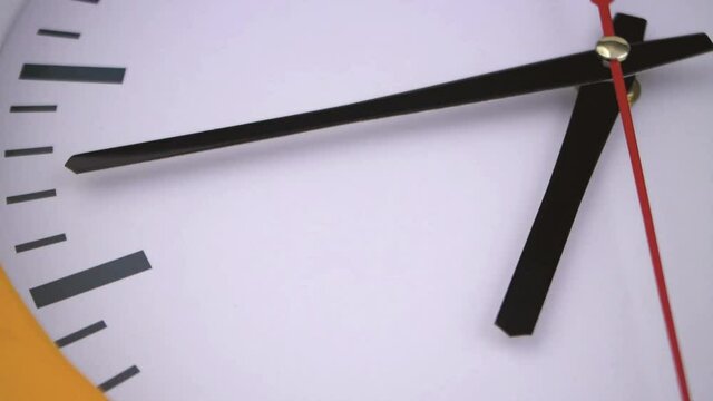 Round clock with black and red pointers close up