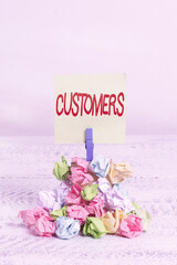 Word writing text Customers. Business photo showcasing individual or organization purchasing products or services Reminder pile colored crumpled paper clothespin reminder white wooden space