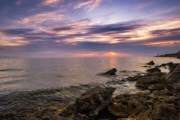 Dramatic sunset over beach with a natural pond in the foreground.