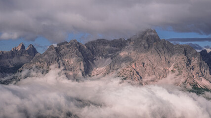Unusual view of the Sesto Dolomites in Italy wrapped in clouds from top to bottom as seen from Carnic Peace Trail from Sillianer refuge to Obstansersee refuge on top of the Carnic Alps ridge, Austria.