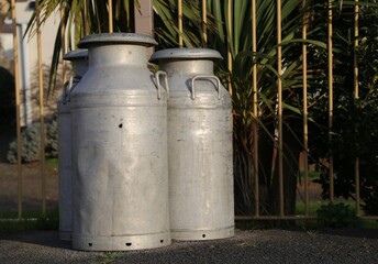 Milk cans  on the platform of an old, railway station.