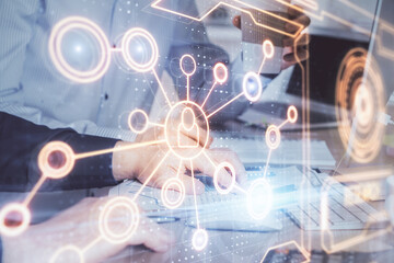 Social network theme hologram with businessman working on computer on background. Multi exposure.