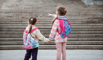 Back to school, Two girls hold hands and go to school.