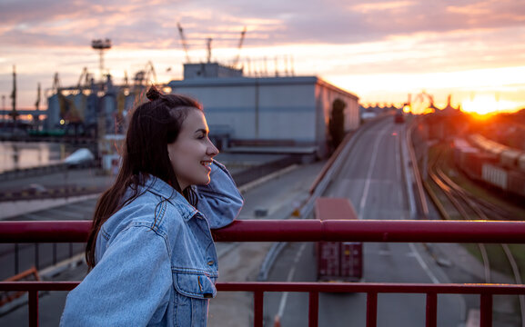 A young woman on the bridge, photographed at sunset .