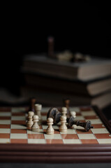 old chess on the table next to a stack of books