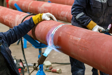 Manual preheating with a flame torch to joint of the pipeline before welding. It involves heating...
