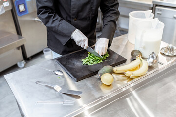 Chef preparing ingredients for making ice cream or yogurt on the kitchen of a small manufacturing. The process of an exotic ice cream preparing