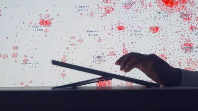 Scientists look at Covid-19 map of the USA on computer
