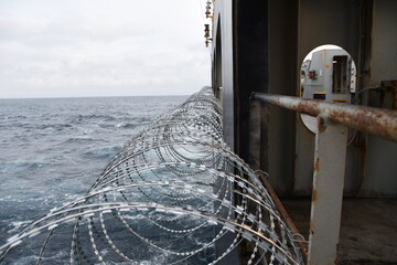 Barbed wire attached to the ship hull, superstructure and railings to protect the crew against...