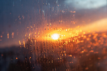 wet the window glass and the reflection of the sunset, the texture of the glass with rain drops.