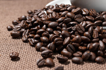 Coffee beans and a cup of coffee on a sackcloth.