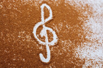 High angle shot of brown species sprinkled on a white background and  musical clef on the center