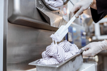 Pile of ready-made ice cream falling out of the freezer at the manufacturing, close-up
