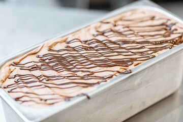 Ice cream with chocolate in the metal tray on the kitchen, close-up