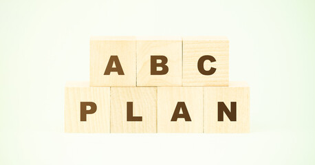 letters abc and word plan on wooden blocks against green