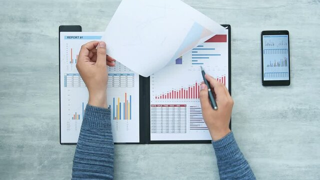 Top View of Trader Hands Counting Profit And Financial Results In Clipboard. Finance and trade concept.